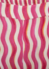 Pantalon wideleg de tiro medio con cintura elástica, confeccionado en tejido fluido de viscosa con estampado de ondas verticales en tonos fucsia, rosa y naranja.