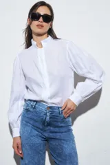 Camisa blanca de lino con cuello mao y mangas largas con frunce en los puños.