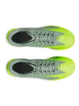 Championes de fútbol Under Armour Shadow Select 3 Turf, diseñados para césped artificial. Presentan un empeine sintético suave y resistente en color gris con detalles en amarillo neón, incluyendo el logo de la marca en negro. Cuentan con suela de goma con tacos multidireccionales para un agarre óptimo.