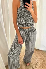 Pantalón de corte recto y holgado, con estampado de cuadros vichy en rojo y blanco. Tiene cintura elástica con cordón ajustable.