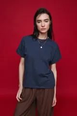 Remera negra de manga corta con cuello redondo y silueta amplia, de hombros caídos y textura suave.
