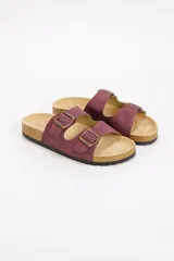Sandalia plana estilo Birkenstock color bordó, con doble tira ajustable mediante hebillas metálicas en tono bronce y suela de corcho con base de goma.