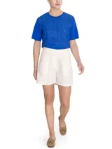 Short estilo cargo tiro alto de lino orgánico color beige, con pinzas frontales, amplios bolsillos laterales con solapa y botones, y trabillas para cinturón.