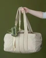 Bolso azul acolchado con doble asa de mano y correa de hombro ajustable.