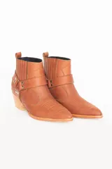 Bota texana de cuero de oveja italiano impermeabilizado, con diseño de caña corta, taco cuadrado y detalle de correa con apliques metálicos en níquel.