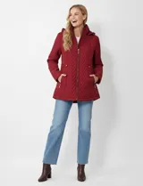 Campera acolchada color rojo oscuro (vino/bordó) con diseño capitoné en patrón de espiga (chevron). Posee cierre frontal, bolsillos laterales con cierre y capucha desmontable.