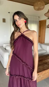 Vestido largo color bordó con escote halter y detalles de volados diagonales.