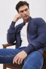 Cardigan de punto grueso color azul marino, con cuello alto, cierre frontal de botones y ribetes en contraste color marrón.