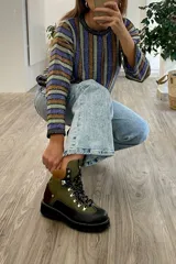 Borcego de cuero verde con detalles en marrón y negro, con cordones y suela track.