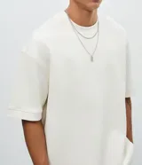 Remera oversize de algodón color gris, con cuello redondo, manga corta y sisa desplazada, de la marca Blue Steel.