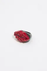 Anillo con forma de labios rojos con cristales incrustados y base negra.