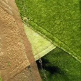 Poncho verde esmeralda de lana merino afieltrada con cuello alto y estampado dorado con diseño abstracto.