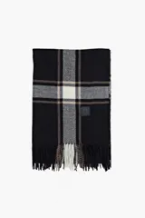 Bufanda de tejido suave con diseño de cuadros escoceses en tonos negro, gris y blanco, con flecos en los extremos y etiqueta decorativa.