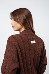 Sweater marrón de punto trenzado con cuello alto y mangas largas.