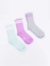 Pack de tres pares de medias de caña corta, con diseño de rayas en la parte superior. Incluye un par celeste con rayas blancas, un par lila con rayas blancas y un par gris con rayas lilas.