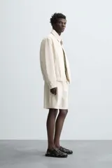 Cazadora de hombre color beige claro, de corte relajado, con cuello solapa, cierre frontal de cremallera y puños y bajo elásticos. Presenta una textura de rayas sutiles y efecto lavado.