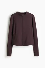 Campera deportiva de corte ajustado en tejido funcional con tecnología DryMove. Presenta cuello elevado, cierre frontal con protección para el mentón, mangas raglán extralargas con abertura para el pulgar y bolsillos laterales con cierre.