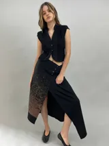 Chaleco negro de lana con diseño estructurado, cuello alzado y detalle de alforzas verticales en los laterales. Presenta cierre frontal con botones metálicos y corte a la cintura.