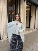 Poncho de hilo liviano en color verde claro, con diseño de cuello alto y caída fluida, ideal para media estación.