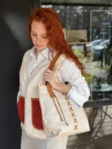 Bolso tipo tote de cuero color crudo con costuras decorativas en hilo color cuero. Tiene doble asa de cuero color cuero y forro interior de tela.