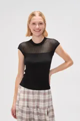 Remera de punto al cuerpo con diseño calado en la parte superior y cuello redondo, de manga corta.