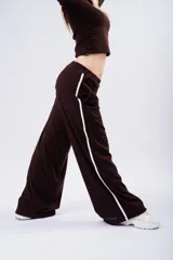 Pantalón tipo palazzo de corte amplio y fluido, color marrón con textura acanalada. Presenta una franja lateral blanca que recorre toda la pierna y cintura elástica.