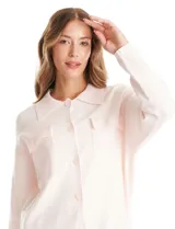 Sobrecamisa tejida de punto, marca Elie Tahari, en color rosa claro. Presenta cuello con solapa, cierre frontal con botones y dos bolsillos aplicados en el pecho.