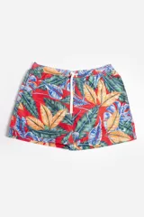 Short de baño con estampado tropical de hojas en tonos verdes, amarillos y azules sobre fondo rojo. Cuenta con cintura elástica con cordón ajustable, bolsillos laterales y suspensor interno.