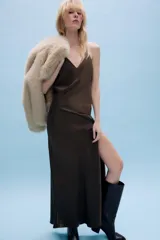 Vestido largo de satén color marrón, con escote en pico, tirantes finos cruzados en la espalda y abertura lateral en el bajo delantero.