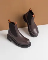 Botas tipo Chelsea de cuero color marrón con paneles elásticos laterales negros y suela track de goma negra con plataforma.