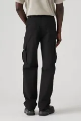 Pantalón cargo negro de corte recto con bolsillos laterales con fuelle y solapa con botón a presión. Tiene bolsillos delanteros y traseros.