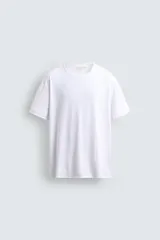Camiseta de corte relajado confeccionada en algodón ligero, con cuello redondo y mangas cortas con terminaciones irregulares.