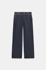 Pantalón de tiro medio de pernera ancha, color azul marino, con bolsillos delanteros y detalle de vivos en contraste de color blanco. Cierre frontal con cremallera y botón.