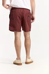 Short de baño azul, de corte clásico y largo corto, con cintura elástica y cordón ajustable bicolor. Cuenta con bolsillos laterales y uno trasero.