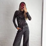 Top negro de mangas largas con estampado de líneas plateadas.