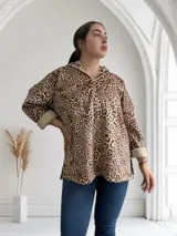 Buzo con capucha y cierre parcial con cremallera, de corte holgado y estampado animal print. Tiene puños y ruedo con ribete de piel sintética.