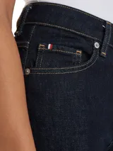 Pantalón de jeans azul oscuro, de corte recto, con bolsillos delanteros y traseros, y costuras en hilo amarillo.