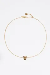 Collar de cadena fina dorada con un dije central en forma de cabeza de pantera esmaltada con detalles en negro y cristales. Incluye cierre de mosquetón y cadena de ajuste.