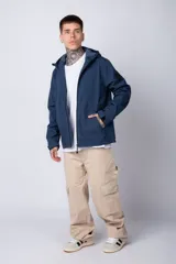 Campera de abrigo color azul, con cierre frontal, capucha ajustable y bolsillos laterales con cierre. Presenta un diseño minimalista con detalle de logo circular en la manga.