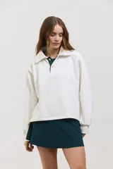 Buzo de algodón con diseño bicolor en blanco y verde inglés, cuello tipo chomba con botones frontales, mangas largas con puños y corte holgado a la cintura.