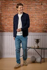 Sobre camisa de lana melange en color azul marino, con cuello camisero, cierre frontal de botones y dos bolsillos frontales con solapa.