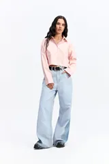 Camisa crop de corte relajado, con cuello clásico, cierre frontal de botones y mangas largas con puños. Confeccionada en algodón, presenta un diseño versátil y moderno.