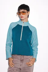 Sweater verde con cierre al cuello, de corte holgado y mangas largas.