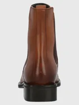Bota tipo chelsea de cuero color marrón, con paneles elásticos laterales en color marrón oscuro, suela de goma negra y taco cuadrado bajo.