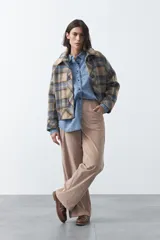 Pantalón de pana color marrón chocolate, de corte recto con bolsillos laterales y cierre frontal.