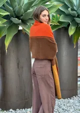 Pashmina de lana con diseño de bloques de color en gris oscuro, gris claro, blanco y negro. Presenta costuras decorativas en contraste.