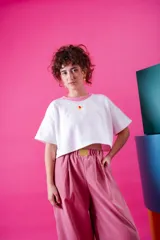 Pantalón de corte holgado y estilo japonés, color rosa, confeccionado en poliéster. Presenta cintura elástica con un aplique decorativo de acrílico en el frente y bolsillos laterales.