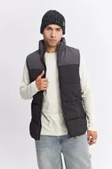 Chaleco puffer bicolor con diseño en bloques, cierre frontal y bolsillos funcionales. Presenta un ajuste regular y logo de la marca estampado en el pecho.