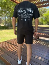 Remera oversize negra de manga corta, con gran estampado tipográfico blanco en la espalda con la inscripción "TOP STYLE Collections" y detalles gráficos.