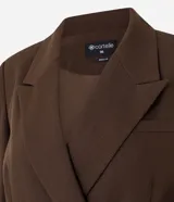 Blazer oversized estructurado marrón de corte cruzado con solapa amplia, bolsillos integrados y cuatro botones frontales.